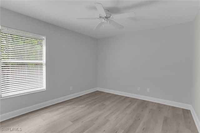 unfurnished room featuring ceiling fan, light wood finished floors, and baseboards