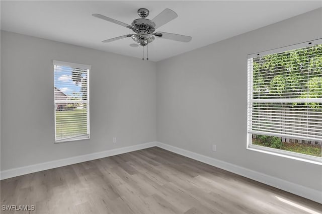 spare room with ceiling fan, baseboards, and wood finished floors