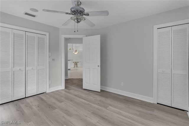 unfurnished bedroom featuring ceiling fan, light wood finished floors, visible vents, and baseboards