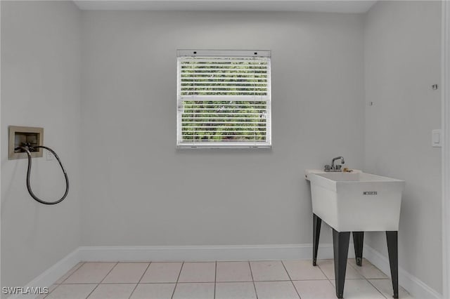 laundry area with washer hookup, laundry area, baseboards, and light tile patterned floors