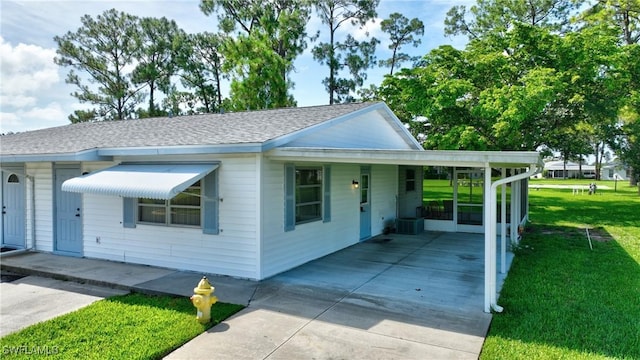 view of front of property featuring a front yard, cooling unit, and a carport