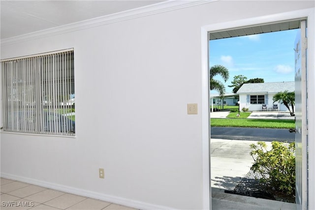 doorway with crown molding and light tile patterned floors