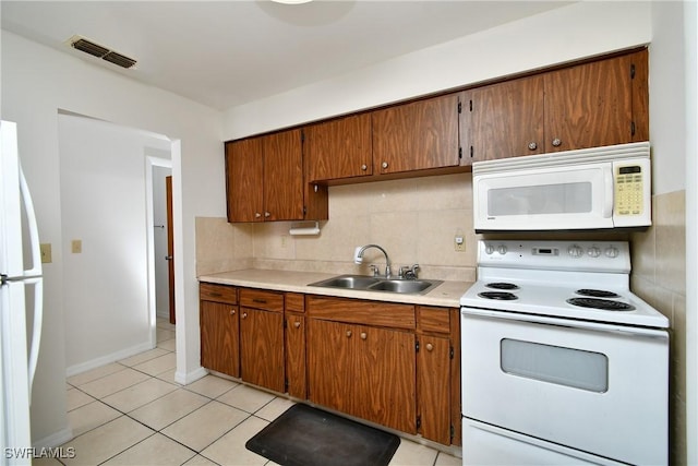 kitchen with sink, white appliances, tasteful backsplash, and light tile patterned flooring