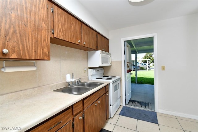 kitchen featuring sink, white appliances, tasteful backsplash, and light tile patterned flooring