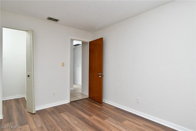 unfurnished bedroom featuring a closet and dark hardwood / wood-style flooring