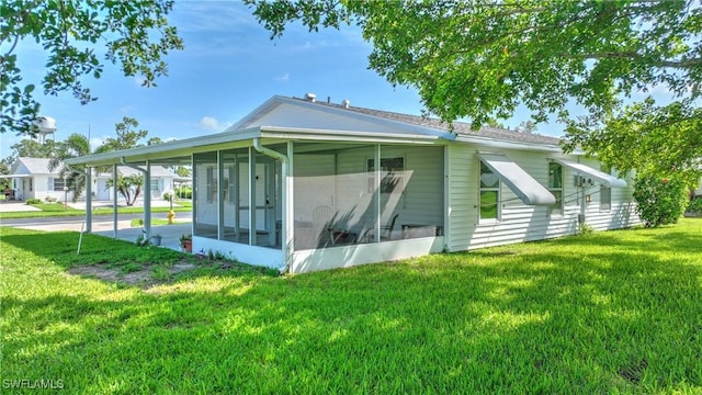 view of side of home featuring a sunroom and a lawn