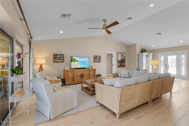 living room featuring lofted ceiling, light hardwood / wood-style floors, and ceiling fan