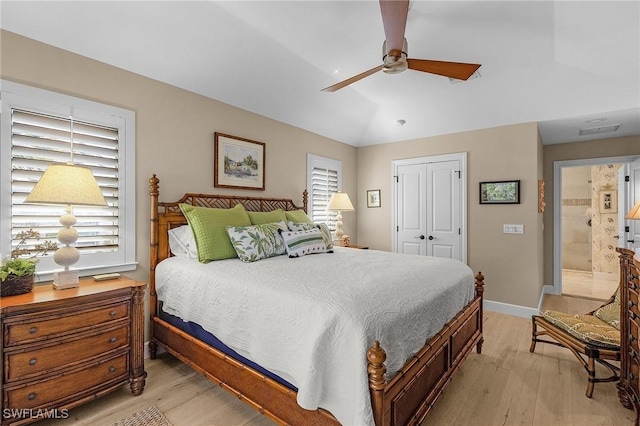 bedroom with ceiling fan, lofted ceiling, a closet, and light wood-type flooring