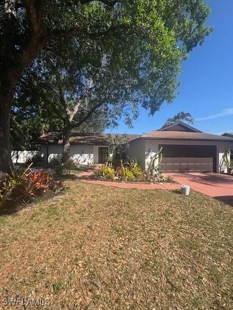 ranch-style house with a garage and a front yard