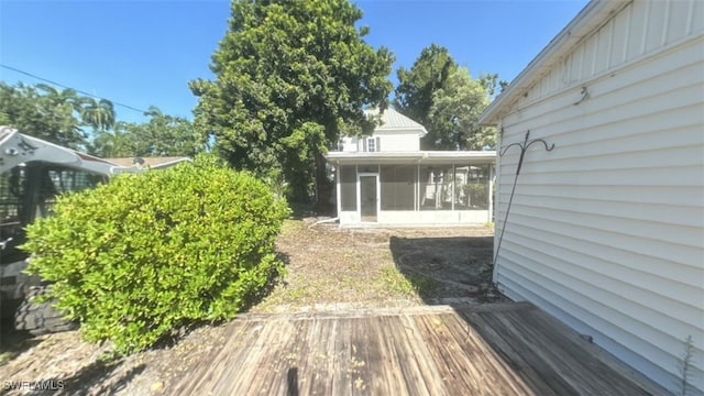 view of yard with a wooden deck and a sunroom