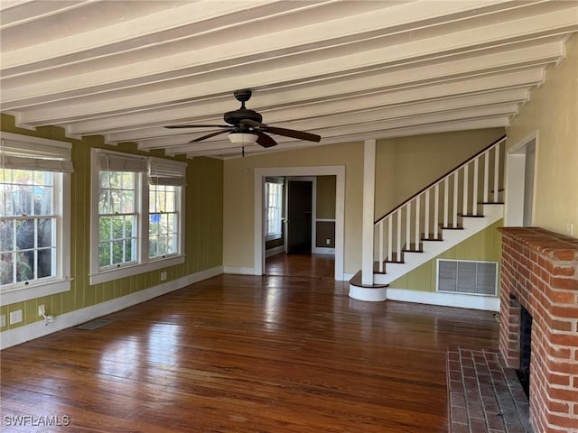 interior space featuring a brick fireplace, beam ceiling, dark hardwood / wood-style floors, and ceiling fan