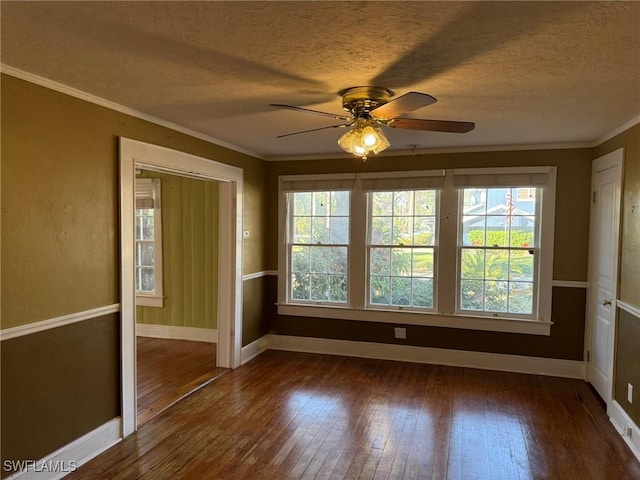 empty room with ceiling fan, crown molding, dark wood-type flooring, and a textured ceiling