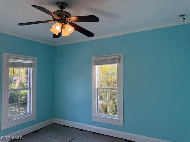 empty room with crown molding, ceiling fan, and a healthy amount of sunlight