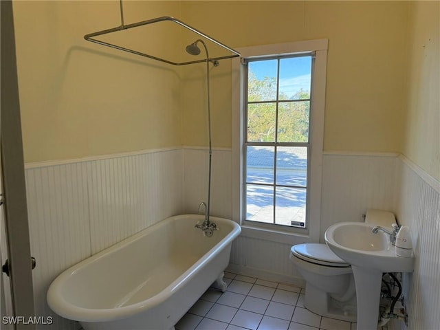 bathroom with toilet, tile patterned flooring, and a washtub