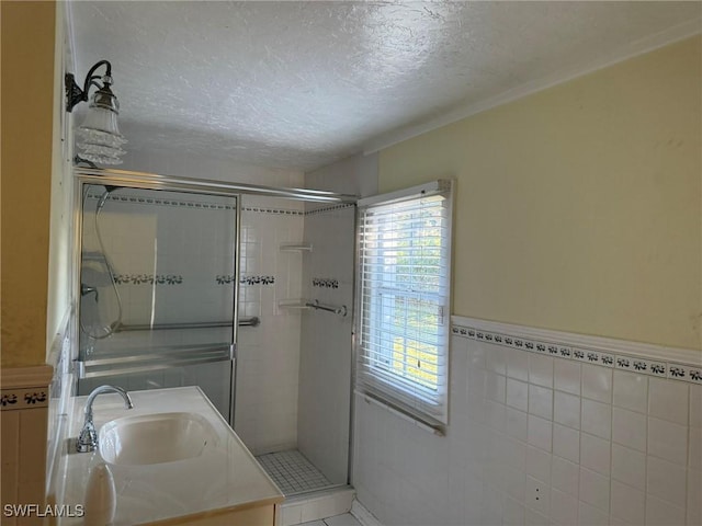 bathroom featuring tile walls, a textured ceiling, a healthy amount of sunlight, and walk in shower