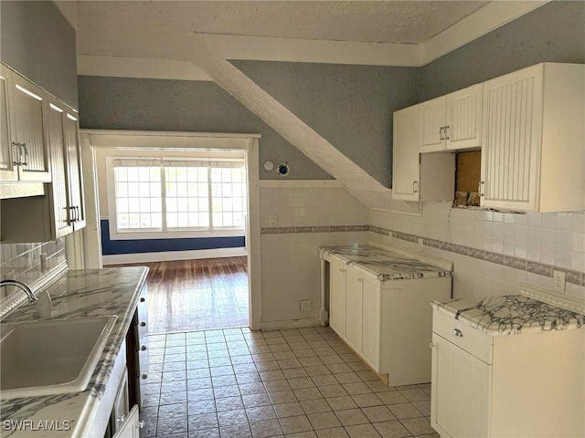 kitchen with white cabinetry, sink, and light tile patterned floors