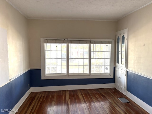 unfurnished room featuring crown molding, dark hardwood / wood-style floors, and a textured ceiling