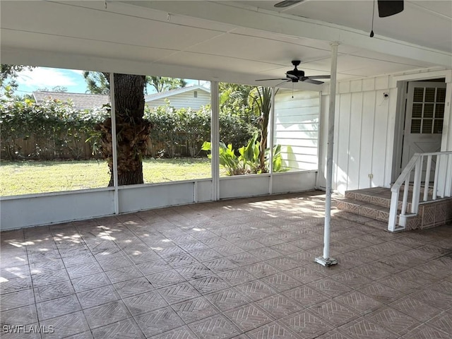 unfurnished sunroom featuring ceiling fan