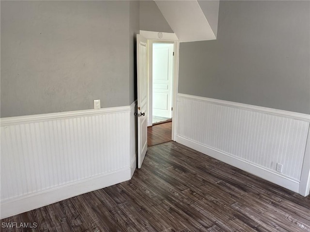 unfurnished room with dark wood-type flooring