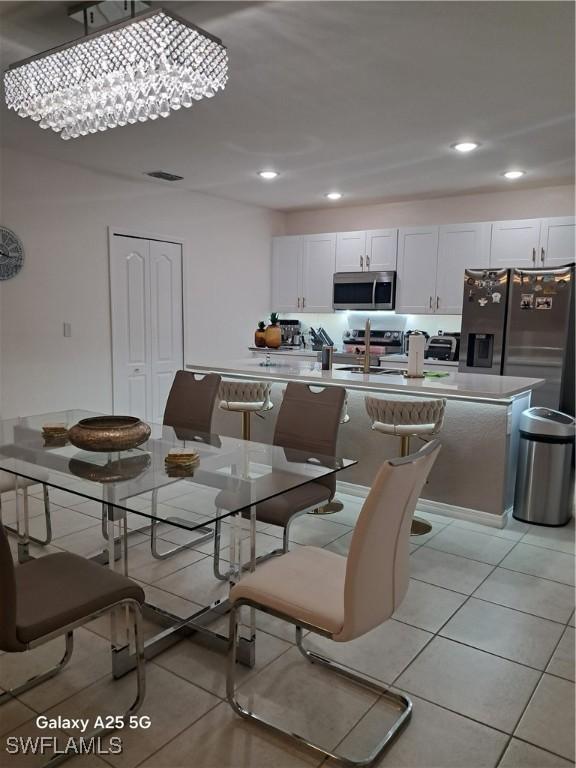 dining area featuring sink and light tile patterned floors