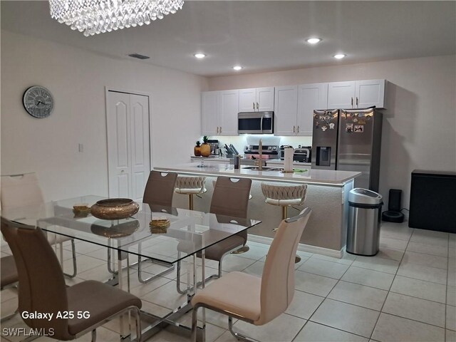 tiled dining room with a chandelier