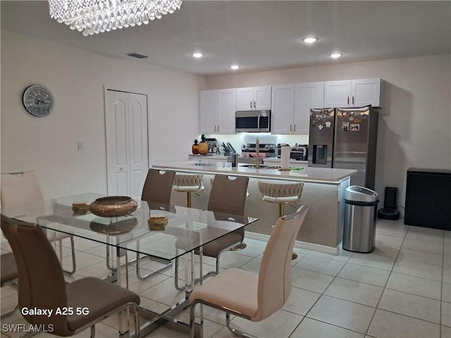 dining space with a notable chandelier and light tile patterned flooring