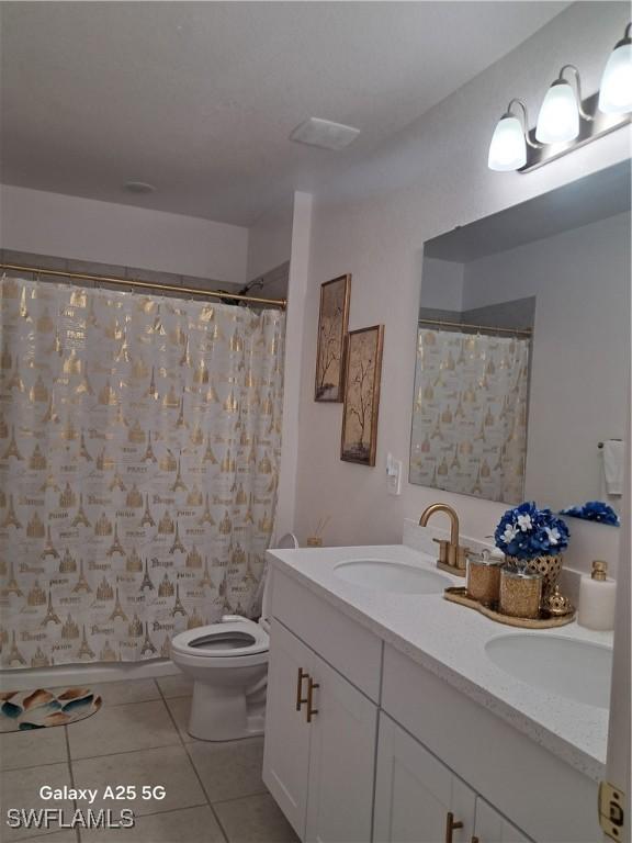 bathroom with a shower with curtain, vanity, tile patterned floors, and toilet