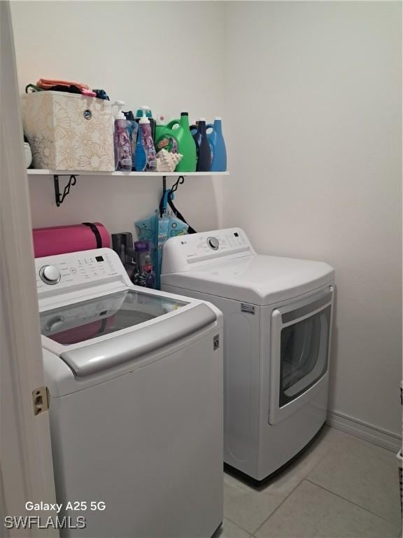 laundry room featuring light tile patterned flooring and washer and clothes dryer