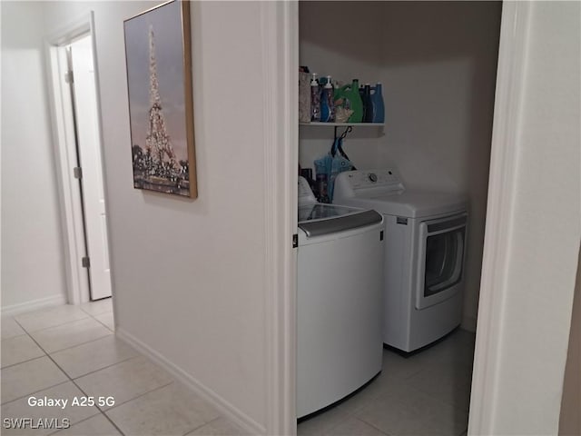 clothes washing area with light tile patterned floors and washing machine and dryer