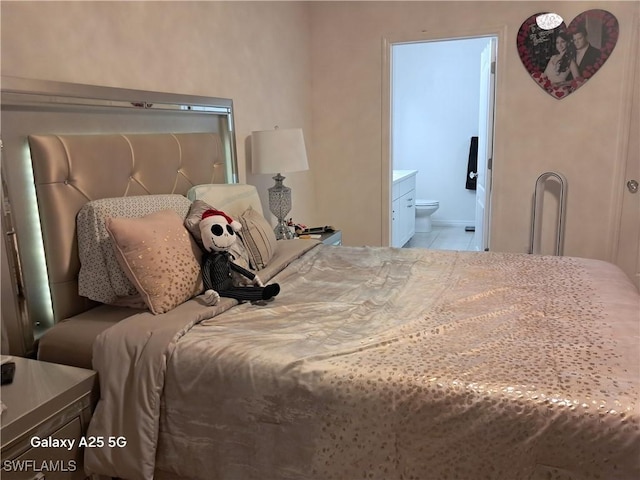 bedroom with connected bathroom and light tile patterned floors