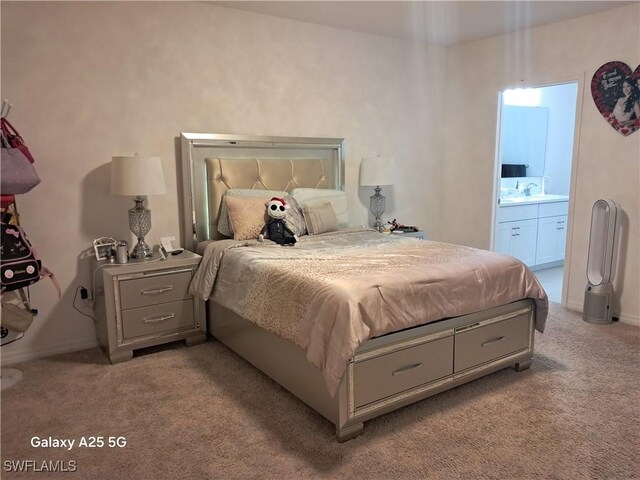 carpeted bedroom with ensuite bath and sink