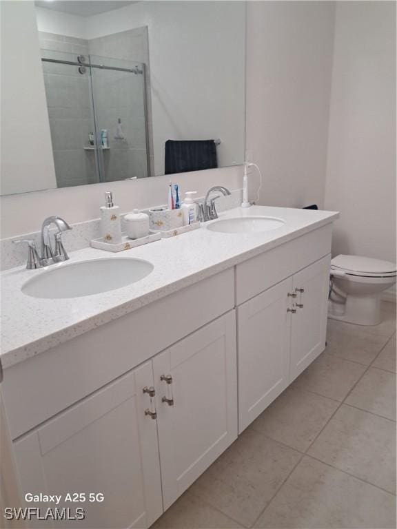 bathroom featuring an enclosed shower, vanity, tile patterned flooring, and toilet