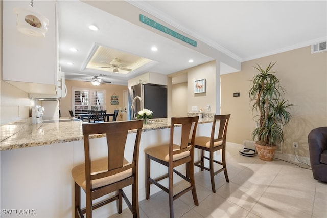 902 SW 48th Ter Unit 104, Cape Coral, FL 33914 - kitchen featuring freestanding refrigerator, a peninsula, stove, a ceiling fan, and a tray ceiling