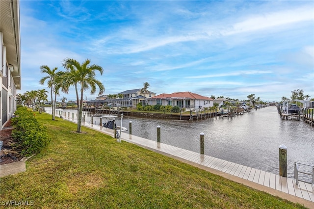 view of dock with a residential view, a water view, and a lawn