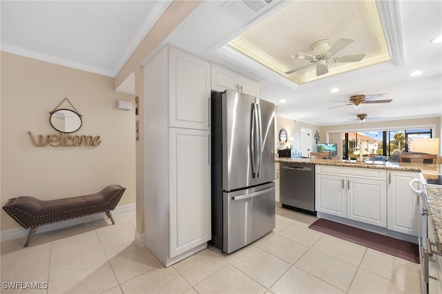 902 SW 48th Ter Unit 104, Cape Coral, FL 33914 - kitchen with stainless steel appliances, a tray ceiling, a ceiling fan, crown molding, and white cabinetry