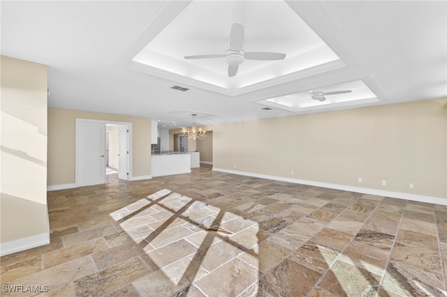 unfurnished living room with a tray ceiling and ceiling fan with notable chandelier