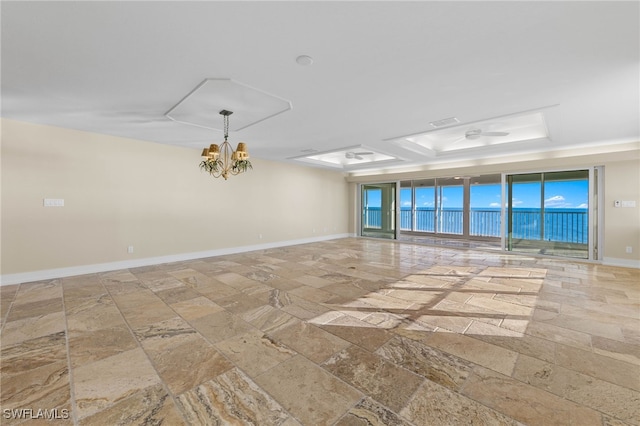 spare room featuring a water view and a notable chandelier