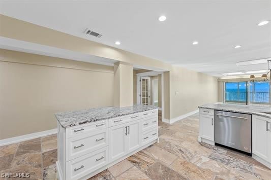 kitchen featuring light stone countertops, dishwasher, a kitchen island, and white cabinets