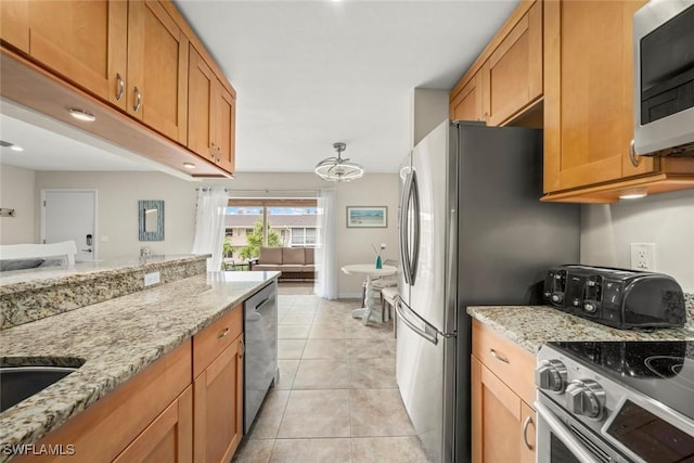 kitchen with light stone counters, stainless steel appliances, and light tile patterned flooring