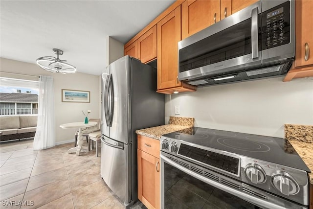 kitchen featuring light stone counters, light tile patterned floors, and stainless steel appliances