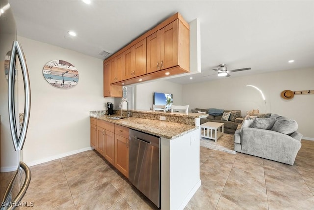 kitchen featuring sink, light stone counters, appliances with stainless steel finishes, kitchen peninsula, and ceiling fan