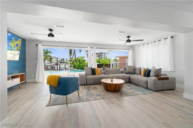 living room featuring light hardwood / wood-style flooring and ceiling fan