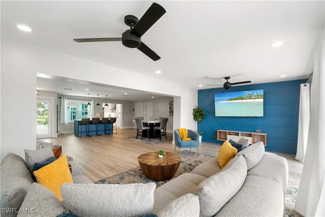 living room featuring ceiling fan and light wood-type flooring