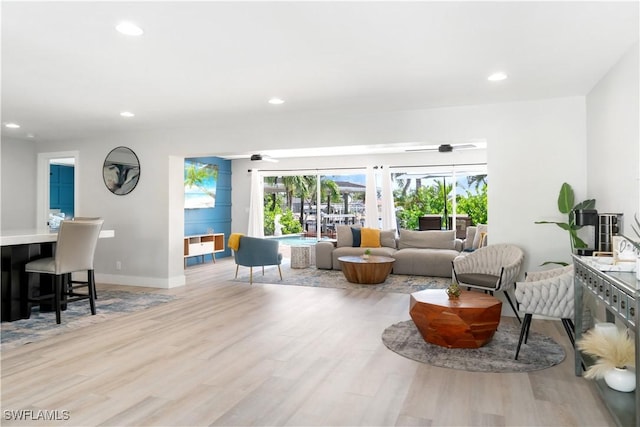 living room with ceiling fan and light hardwood / wood-style flooring