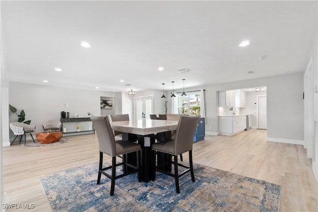 dining room featuring light wood-type flooring and french doors