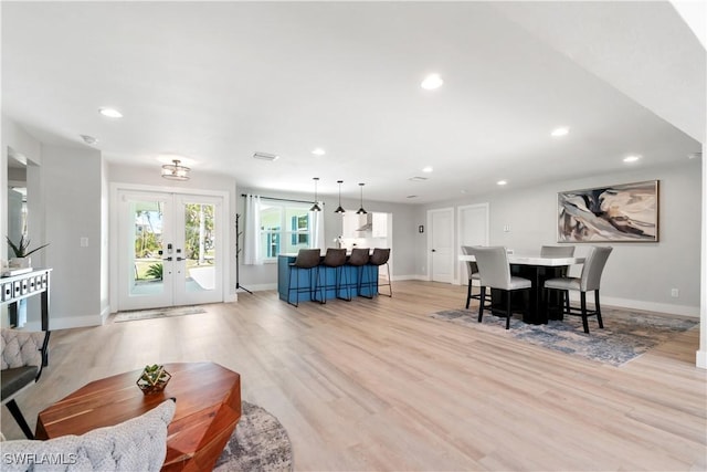 living room with light hardwood / wood-style flooring and french doors