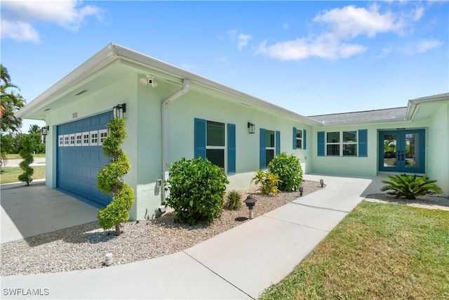 view of side of property featuring a garage and french doors