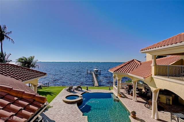 view of swimming pool featuring a pool with connected hot tub, a water view, and a patio