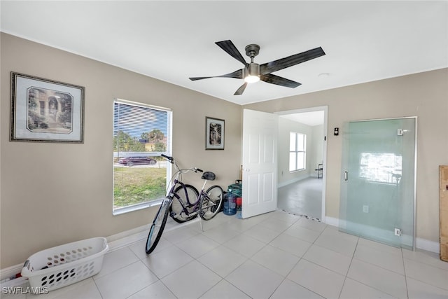 interior space with light tile patterned flooring and ceiling fan