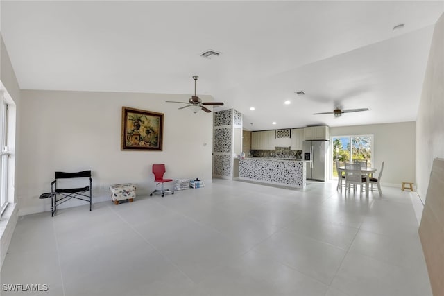 living room featuring ceiling fan and lofted ceiling